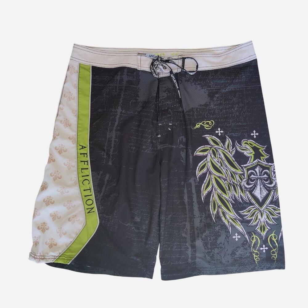 Y2K Affliction black shorts with green/white fleur-de-lis and leaf graphic